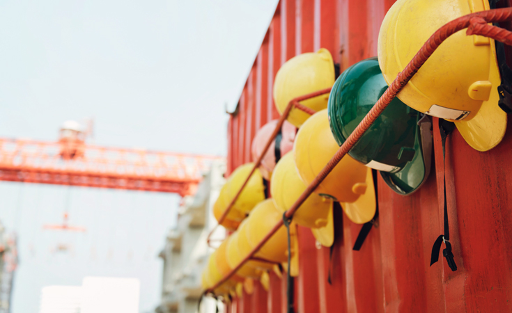 Yellow and green hard hats on a rack © rawpixel.com