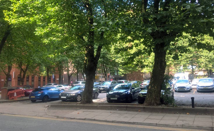 Cars surrounded by trees in a city centre car park © Neil Francis